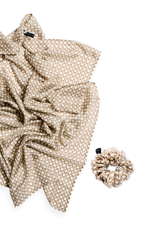 A luxury silk accessory set featuring a large draped scarf and a matching mid-size scrunchie with a neutral rattan cane weave pattern on a white background.