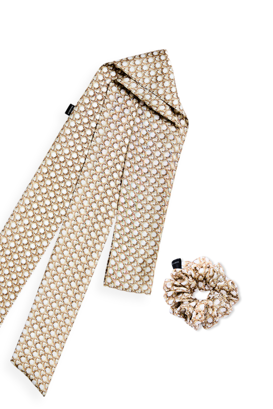 A matching silk accessory set featuring a long skinny twilly scarf and a mid-size scrunchie with a neutral rattan cane weave pattern on a white background.