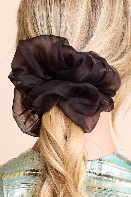 Brown sheer scrunchie on a person with blonde hair against a beige background