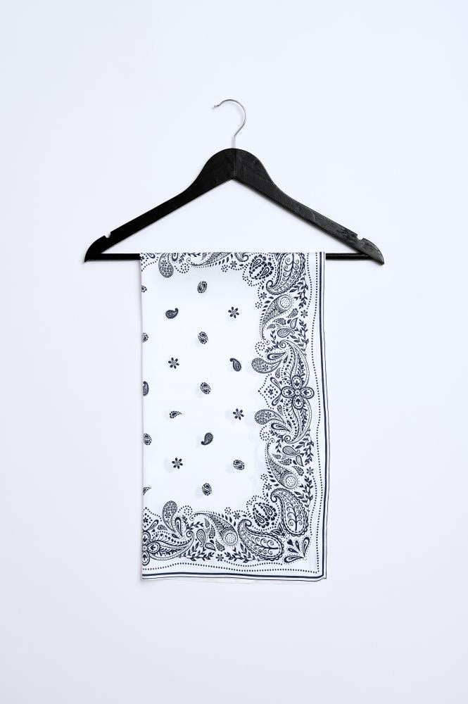 A black and white paisley pattern viscose scarf hanging on a black hanger against a white background.