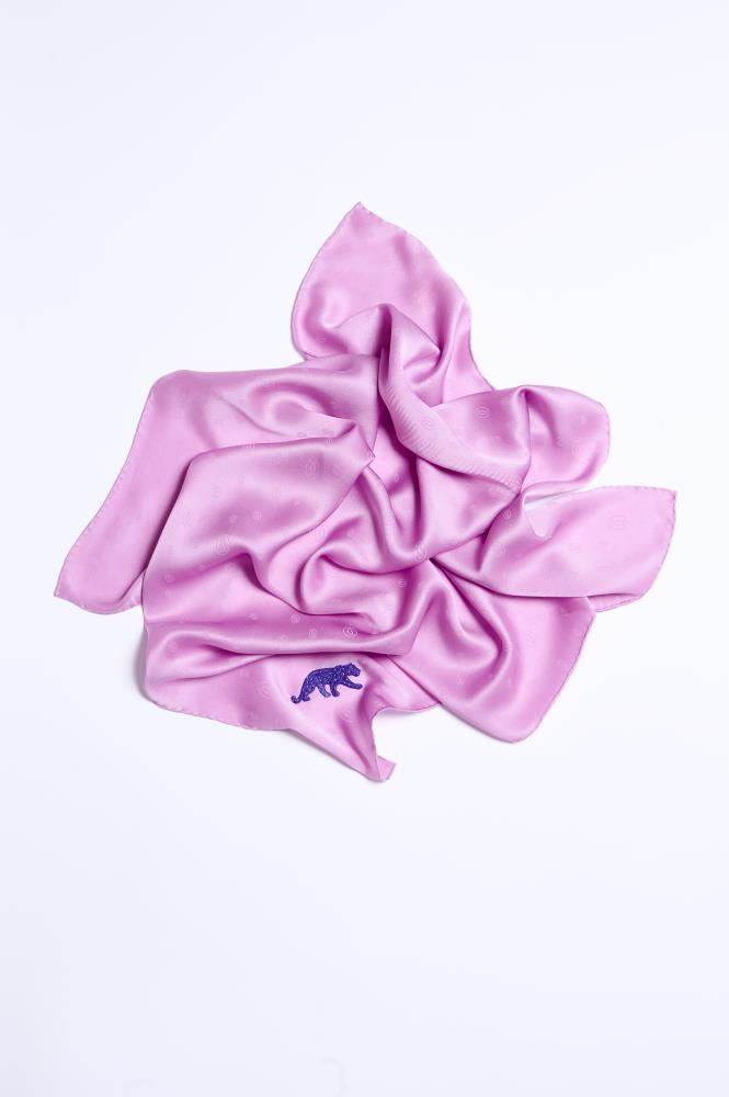 A luxuriously draped lilac pink silk scarf on a white background, featuring a subtle monogram pattern and a distinct purple embroidered panther motif in the corner.