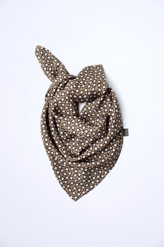 Studio product shot of Skarele TONE viscose scarffolded on a solid white background. Features a beige and dark brown geometric retro dot print pattern.