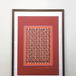 Interior mockup of the "Evening deep red" digital poster framed in a thin dark wooden frame with a white passe-partout mat, resting on a wooden table against a clean white wall.