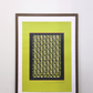 Framed pistachio green digital poster in a dark wooden frame displayed on a wooden surface against a white wall