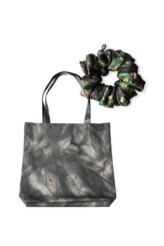 A set featuring a grey patterned water repellent cotton tote bag and a matching dark brown and green details mid-size scrunchie on a white background.