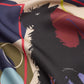 Macro shot of the GUARDIAN Silk Scarf in Blue Graphite, showcasing the intricate black terrier dog sketch. The artistic print features bold geometric elements and whimsical line art in muted earthy and navy tones. The lightweight silk fabric's fluid drape is emphasized, showing off the rich pigmentation and premium craftsmanship of this unique accessory for dog enthusiasts.