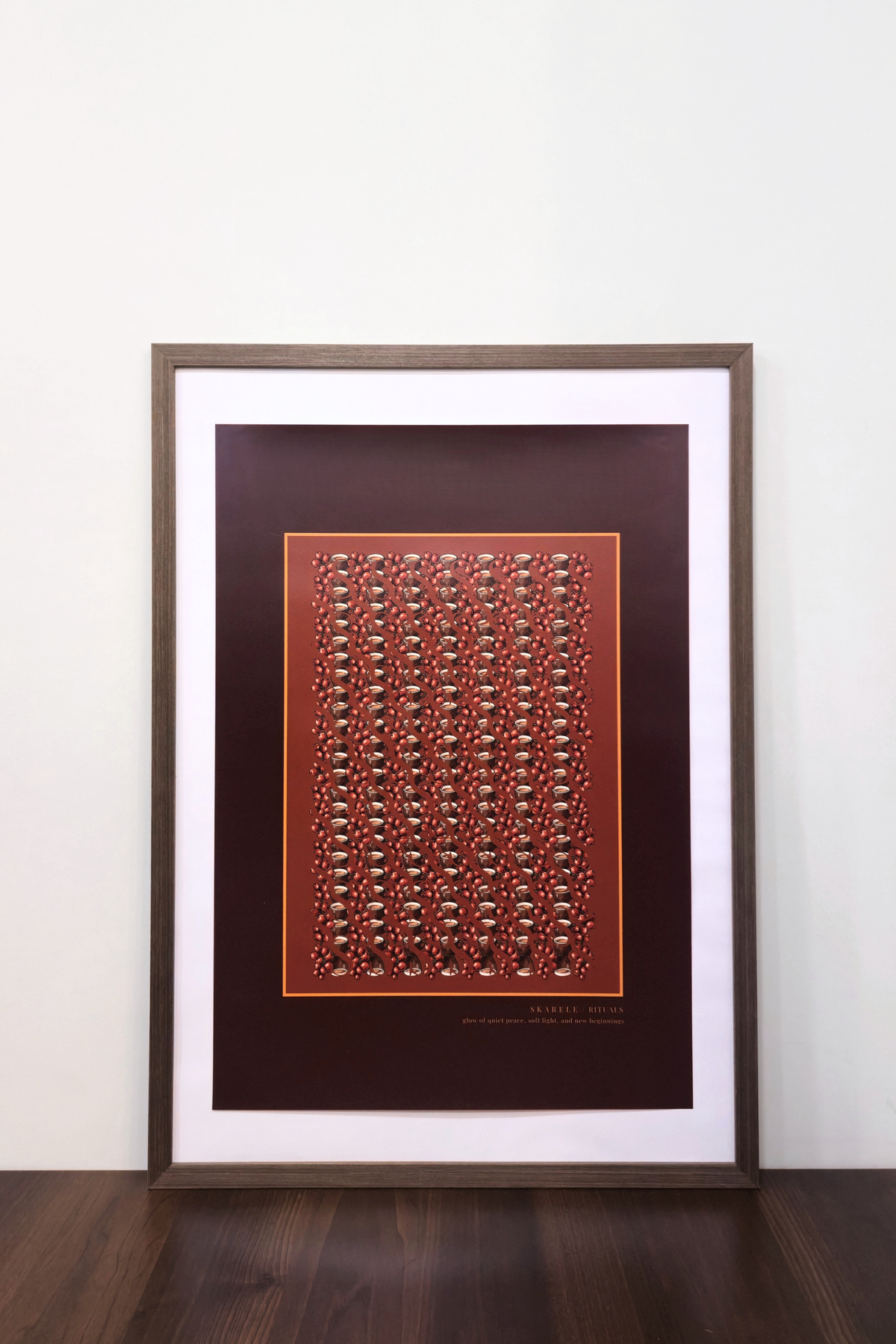 interior mockup of the "Morning bordeux" digital poster framed in a thin dark wooden frame with a white passe-partout mat, resting on a wooden table against a clean white wall.