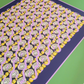 Perspective view close-up of the "Movement citrus yellow" art print, highlighting the high-quality print finish, dark navy center with padel rackets and balls, lilac border line, and wooden frame edge