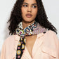 Woman wearing a colorful patterned viscose scarf on a plain background