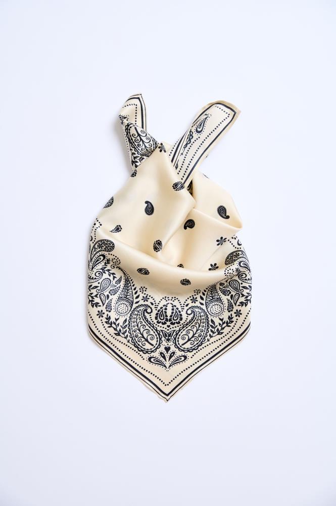 A beige and black patterned scarf tied in a knot on a white background