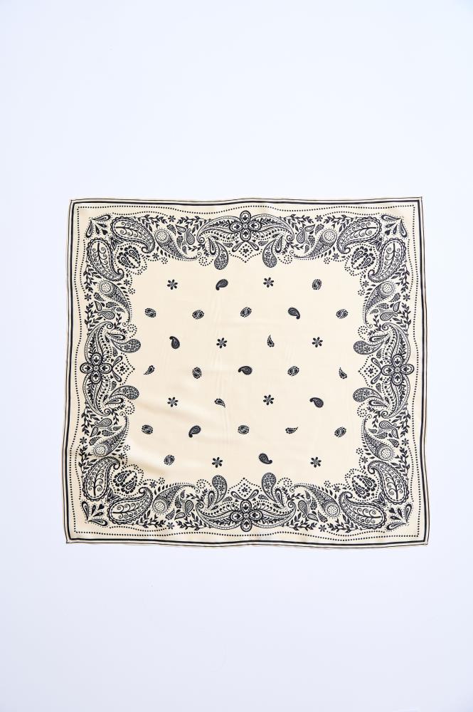 A fully spread-out square, light cream-colored scarf against a white background. The accessory features a symmetrical, classic black paisley pattern, which is most dense along all four edges, forming a decorative border. Smaller motifs of the same style and flower elements are scattered throughout the center of the scarf.