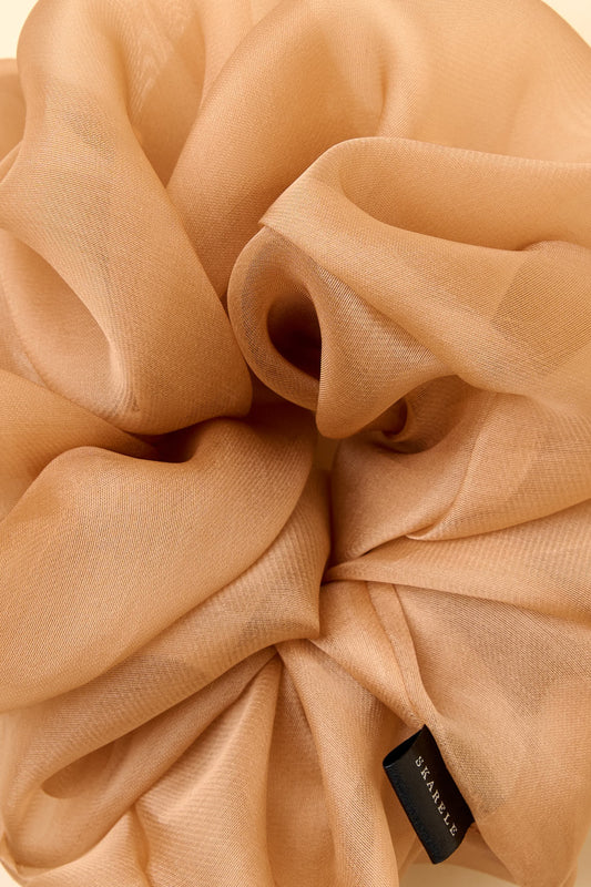 Close-up of silk organza scrunchie with a brand label