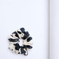 A mid-size black and white silk scrunchie on a light background.