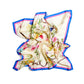 A light cream silk scarf playfully crumpled and laid out on a white background. The fabric is decorated with a delicate floral pattern featuring pink, yellow, and blue blossoms and brown leather strap motifs. The edges of the scarf are framed by a bold double border of blue and pink stripes. The soft silk sheen and deep folds create a sense of luxury and elegance, highlighting the quality of the natural material.