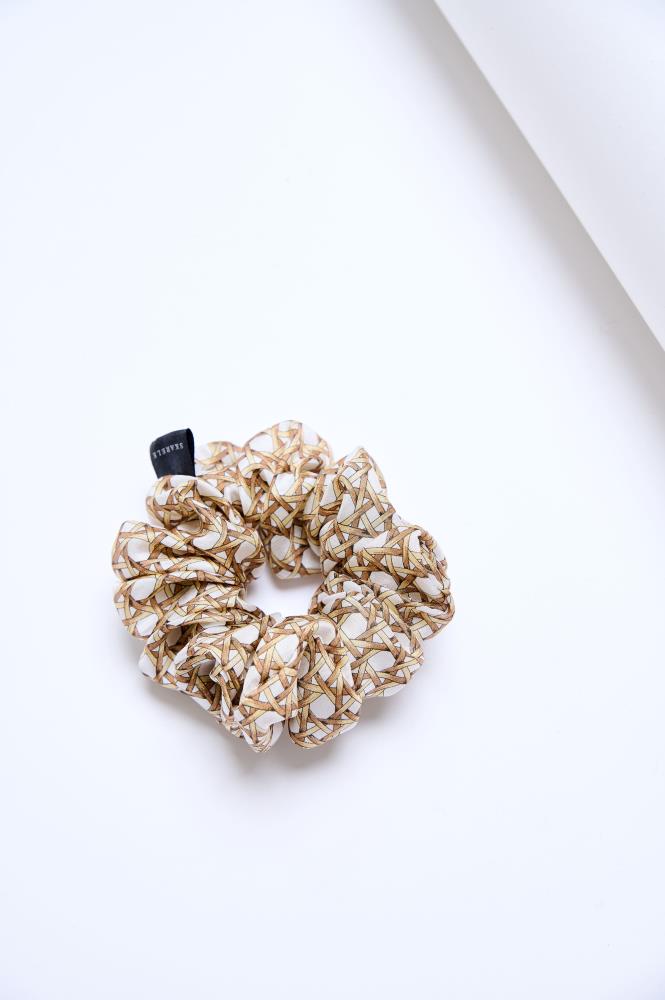 A mid-size silk scrunchie in muted tones of beige, brown, and champagne color, displayed on a white background.