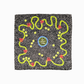 Flat lay of a dark brown-grey square viscose & silk blend scarf with a white dot pattern. Features a wavy lime green border, tiny red crabs, lemon slices, and a center circle with 'la dolce vita' text.