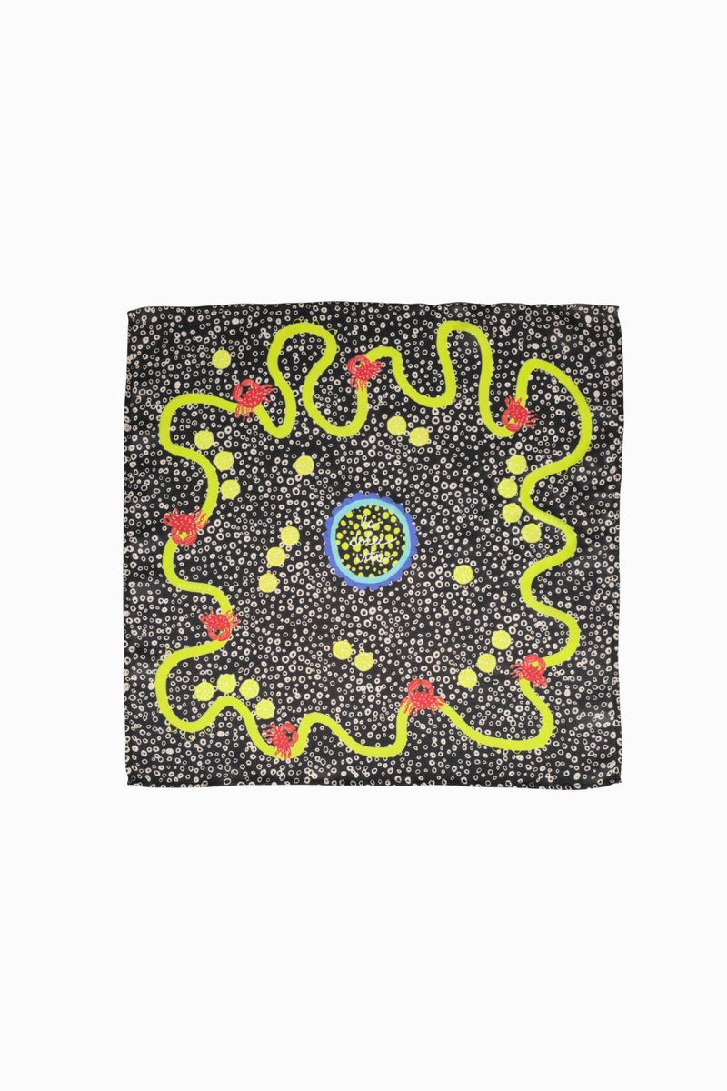 Flat lay of a dark brown-grey square viscose & silk blend scarf with a white dot pattern. Features a wavy lime green border, tiny red crabs, lemon slices, and a center circle with 'la dolce vita' text.
