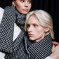 Two models wearing black and white checkered wool scarves.