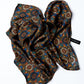 A patterned silk scarf with colors predominantly in brown and black, displayed in a crumpled manner on a white background with a tag visible.
