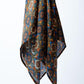 Elegant display of a patterned headscarf with ornate circular and floral motifs, showcasing its fluid drape and high-end silk texture.