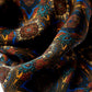 Extreme close-up of a premium silk scarf, showcasing its rich paisley pattern and vibrant blue and gold tones with a soft, lustrous sheen.