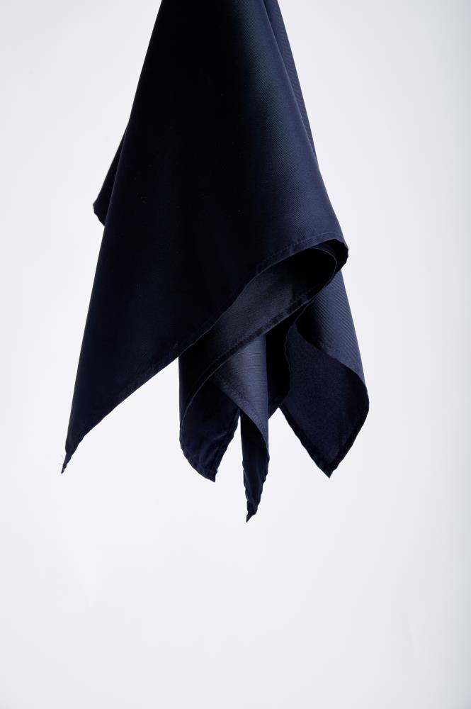 A dark, midnight blue silk scarf is elegantly suspended against a plain white background. The fabric folds create a sense of movement and sophistication.