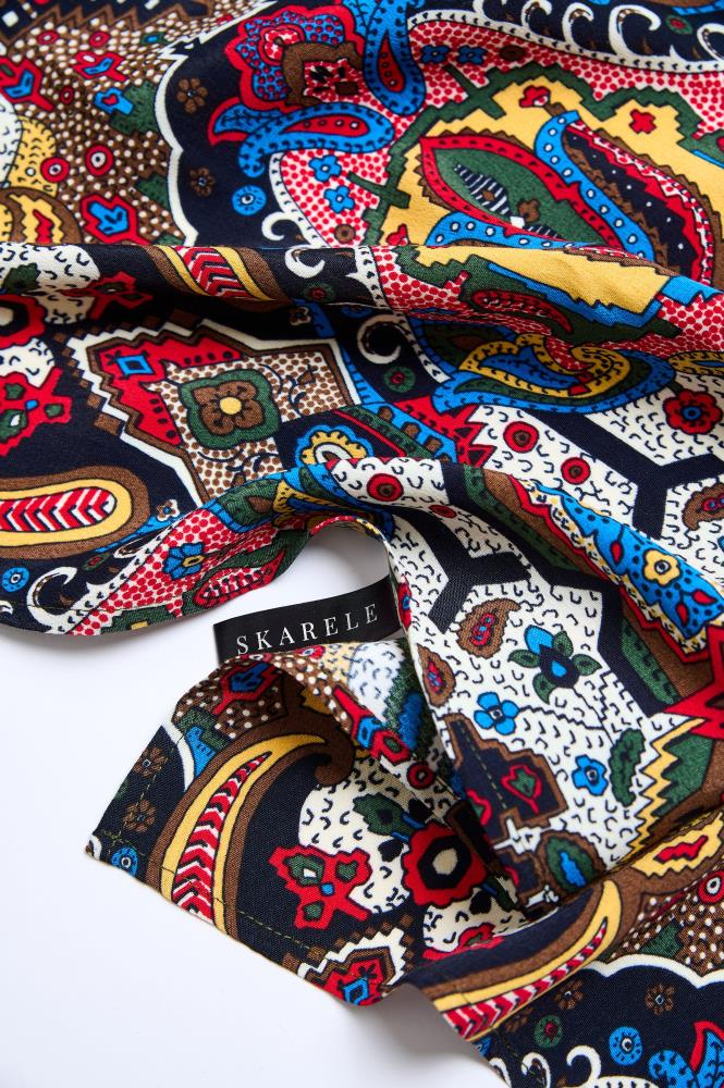 A close-up image of a viscose scarf with a multicolored geometric pattern.