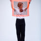 A person holding up a square, semi-transparent  silk scarf in vibrant orange, featuring a dark center panel with an abstract orange leopard-style print.