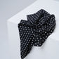 Black scarf with white patterns on a white surface