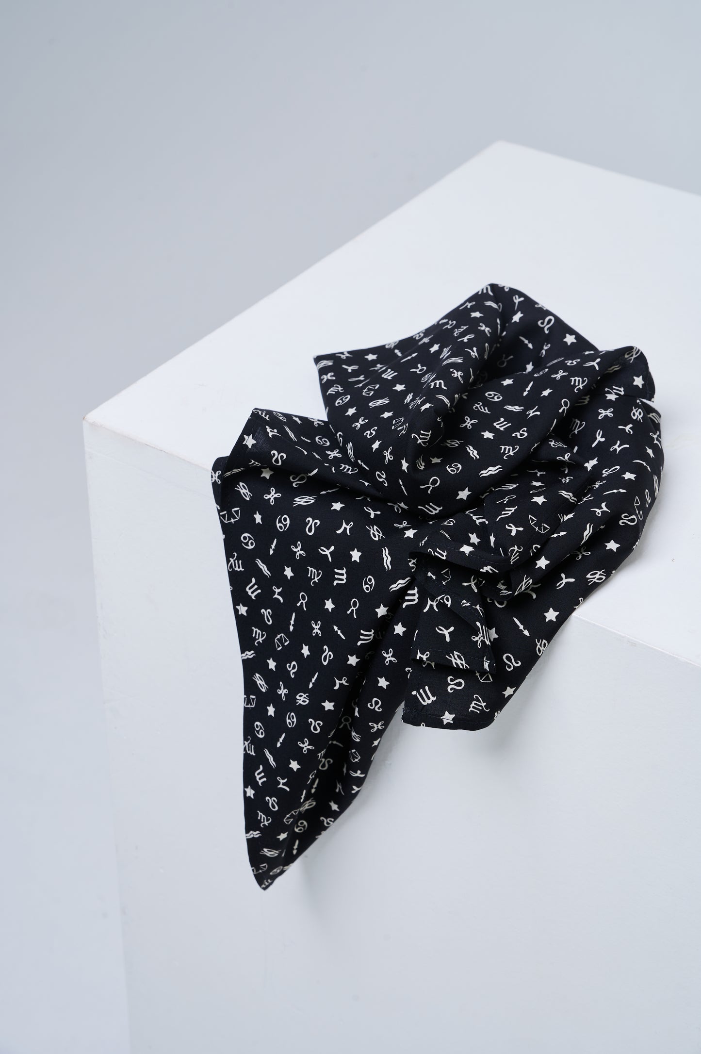 Black scarf with white patterns on a white surface