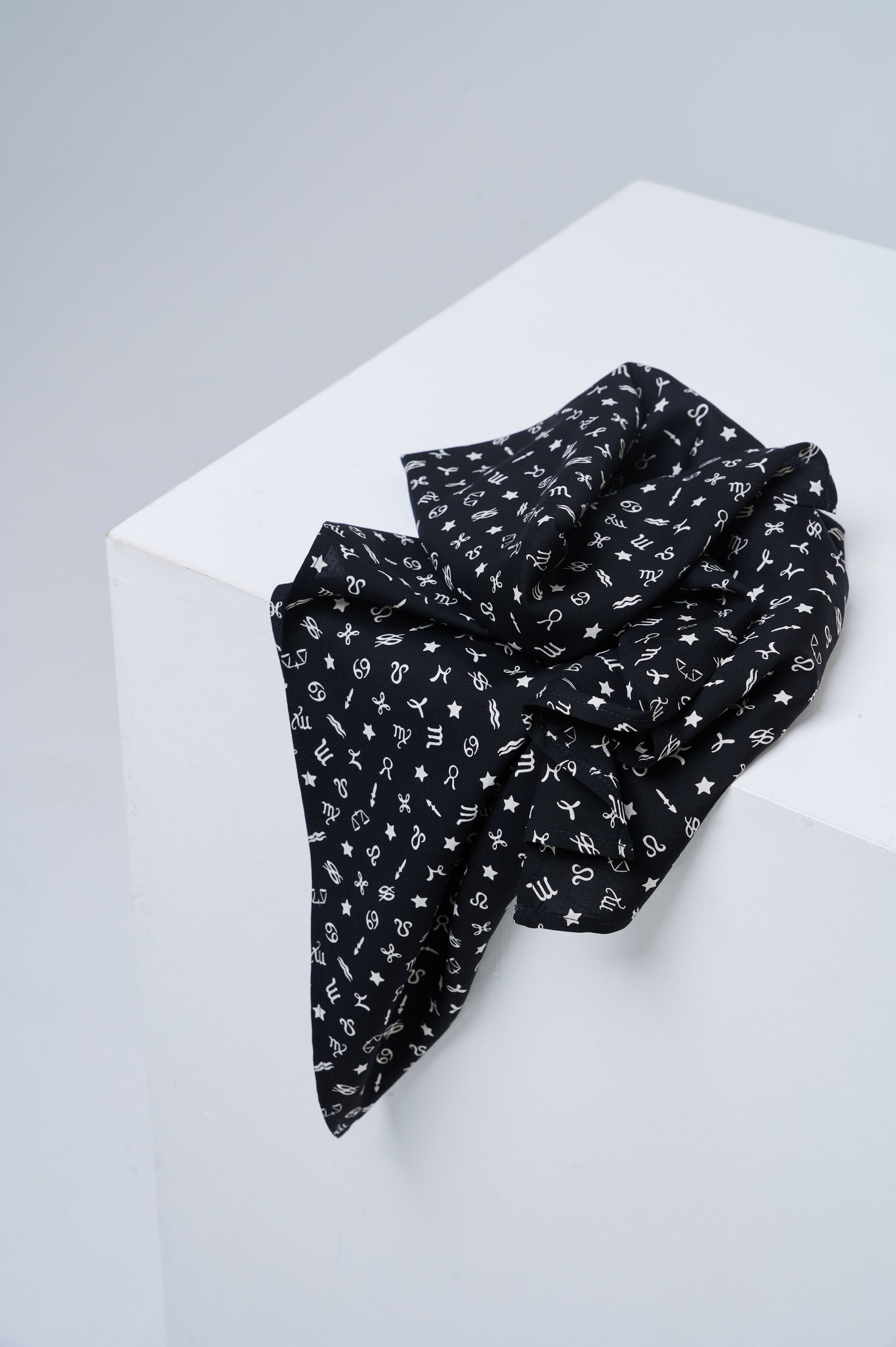 Black scarf with white patterns on a white surface