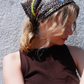 SKARELE Summer La Dolce Vita dark brown bandana headscarf with vibrant olive green and blue abstract pattern, styled on a blonde woman outdoors