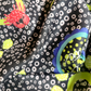 Detailed macro view of SKARELE "Summer La Dolce Vita" dark brown silk blend scarf fabric, featuring a red crab, lemon slices, and abstract polka dot print