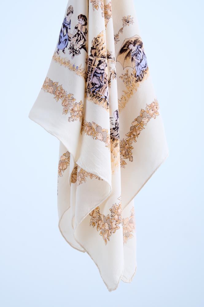 A high-quality cream silk scarf featuring a detailed vintage-style print with violet figurative illustrations, classic Victorian-era scenes, and ornate golden floral borders, artfully draped to showcase the fabric's soft texture.