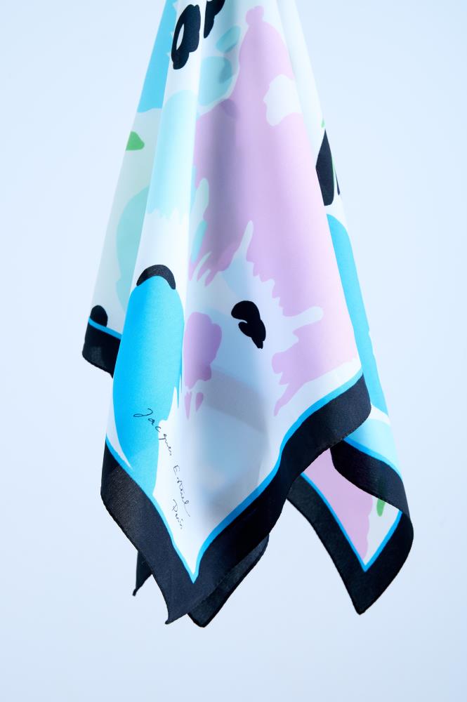 silk scarf with a soft abstract print in pastel pink and sky blue, featuring a bold black border and the designer signature.