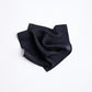 A black silk pocket square  folded neatly.
